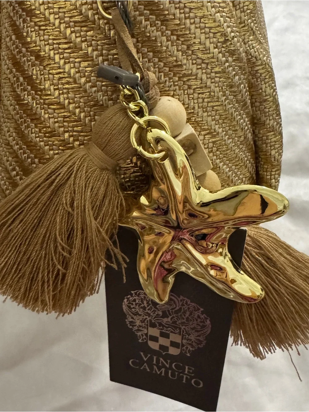 Vince Camuto gold woven canvas metallic cosmetic Bag with starfish Tassel charm.